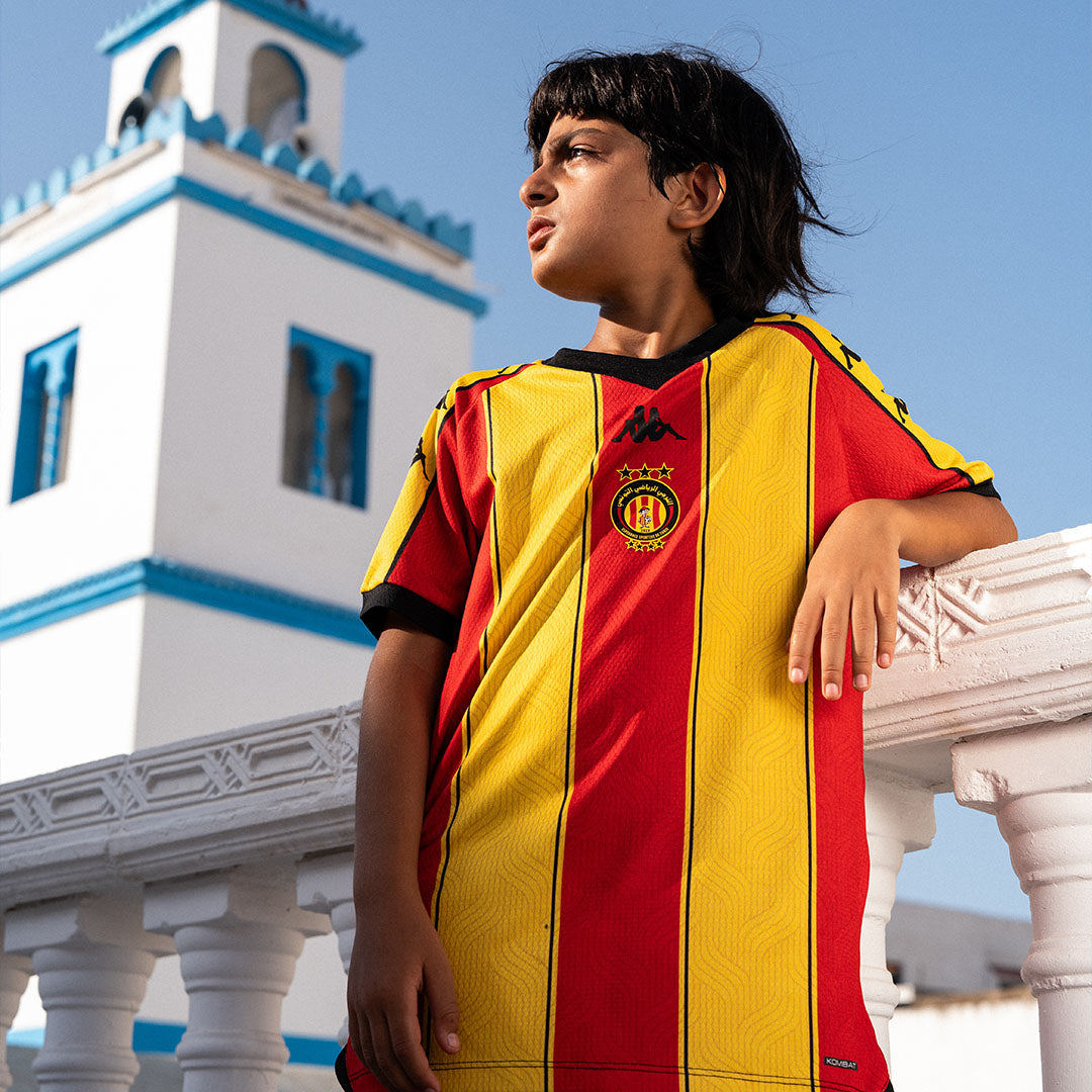 Maillot Kombat Pro Home Espérance Tunis 26/27 Rouge Enfant main